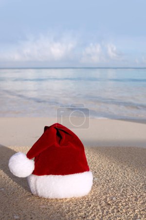 Photo for Merry Christmas hat on the white Caribbean sand. - Royalty Free Image