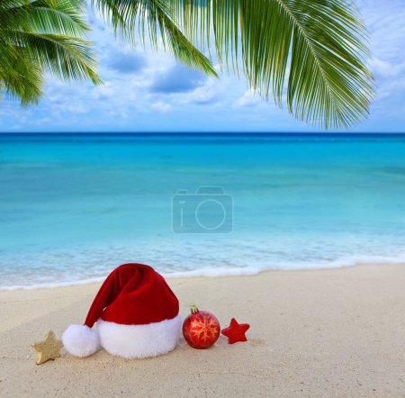 Téléchargez les photos : Chapeau de Père Noël et décorations sur le sable blanc des Caraïbes. - en image libre de droit