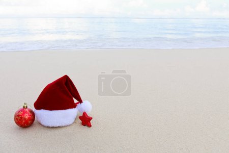 Foto de Feliz Navidad sombrero y decoraciones en la blanca arena del Caribe. - Imagen libre de derechos