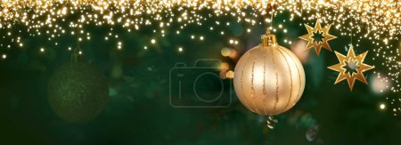 Foto de Rama de árbol de Navidad con bola dorada sobre fondo borroso. - Imagen libre de derechos
