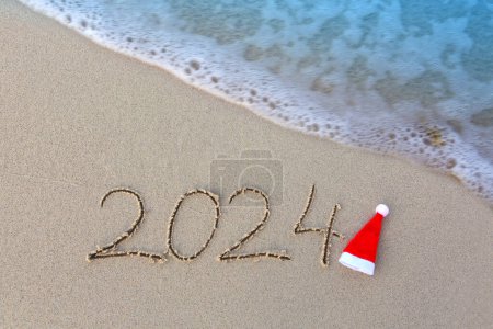 Foto de Feliz Año Nuevo 2024 texto en la playa del mar. - Imagen libre de derechos