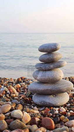 Photo for Pyramid of sea pebbles, composed by the sea. The object is in focus, the background is blurred. - Royalty Free Image