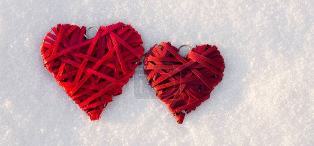 Téléchargez les photos : Deux cœurs rouges sur fond de neige blanche. Saint Valentin - en image libre de droit