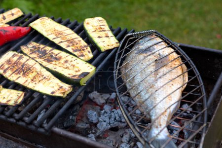 Photo for Dorado fish is grilled on charcoal grill on a sunny summer day. - Royalty Free Image