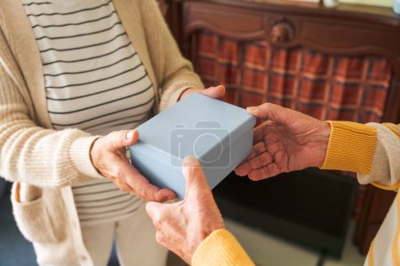 Photo for An elderly couple is exchanging gifts each other. - Royalty Free Image