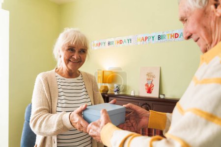 Photo for An elderly couple is exchanging gifts. - Royalty Free Image