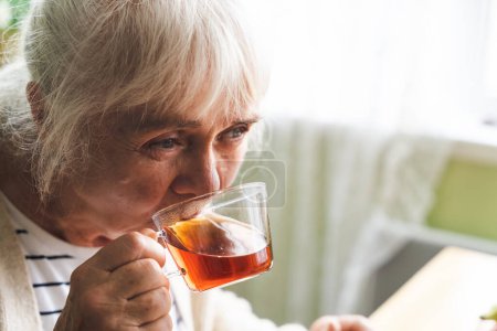 Foto de Un retrato de una anciana tomando té en la cocina. - Imagen libre de derechos