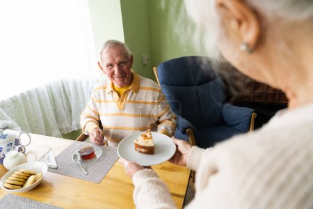 Foto de Para el cumpleaños de sus maridos, la esposa trató a su anciano esposo con un pastel festivo.. - Imagen libre de derechos