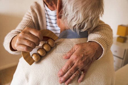 Téléchargez les photos : La vie à la maison de retraite. Heureux seniors sur leur routine à la maison. Physiothérapie, massage du dos. - en image libre de droit