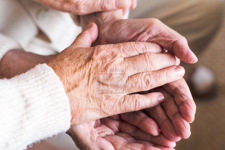 Photo for The hands of the elderly couple tightly hold each other together. - Royalty Free Image