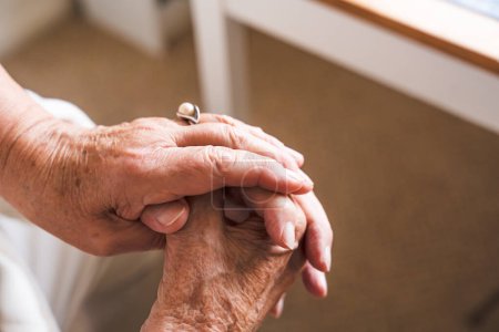Téléchargez les photos : Les mains du couple de personnes âgées se serrent fort les unes contre les autres. - en image libre de droit