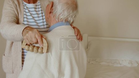 Téléchargez les photos : Femme mûre inquiète donnant un massage à son mari à la maison. Concept de relations heureuses - en image libre de droit