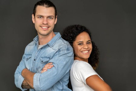 Téléchargez les photos : Romantique jeune couple heureux caucasien homme et afro-américaine femme sourire et s'amuser ensemble dans la Saint-Valentin sur fond noir - en image libre de droit