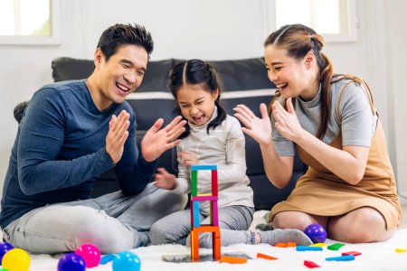 Téléchargez les photos : Portrait de jouir heureux amour asiatique famille père et mère avec peu asiatique fille sourire activité apprendre et compétence cerveau entraînement jouer avec jouet construire des blocs en bois jeu d'éducation à la maison - en image libre de droit
