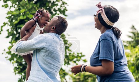 Téléchargez les photos : Portrait de jouir heureux amour noir famille afro-américaine père et mère avec petite fille africaine enfant souriant et jouer avoir des moments amusants bon temps dans la chambre à la maison - en image libre de droit