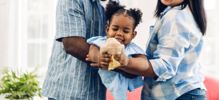 Téléchargez les photos : Portrait de jouir heureux amour noir famille afro-américaine père et mère avec petite fille africaine enfant souriant et jouer avoir des moments amusants bon temps dans la chambre à la maison - en image libre de droit