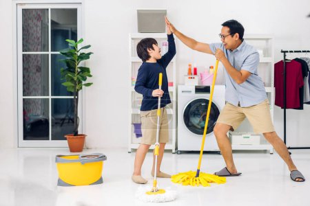 Téléchargez les photos : Père enseignement asiatique enfant petit garçon fils avoir amusant faire ménage corvées nettoyage et lavage sol essuyage poussière avec nettoyage tout nettoyage maison ensemble à la maison - en image libre de droit