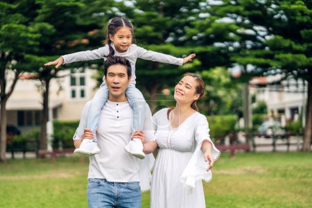 Téléchargez les photos : Portrait de jouir heureux amour asiatique famille père et mère tenant mignonne petite fille asiatique enfant souriant jouer et avoir des moments amusants bon temps dans le parc d'été à la maison - en image libre de droit