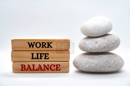 Foto de Texto de equilibrio de la vida laboral en bloques de madera con piedras zen balanceadas. Concepto de cultura de trabajo - Imagen libre de derechos