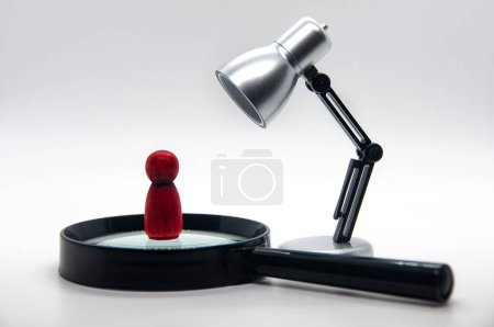 Photo for Red wooden figure on top of magnifying glass with white background. Selection concept. - Royalty Free Image