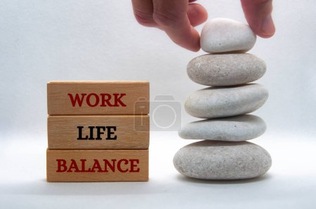 Work life balance text on wooden blocks with balanced white stones background. New ways of working concept
