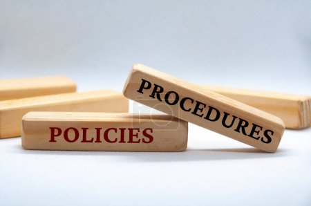 Foto de Policies and procedures text on wooden blocks on white cover background. - Imagen libre de derechos