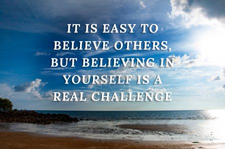 Motivational quotes text - It is easy to believe others, but believing in yourself is a real challenge. With beautiful beach background.