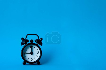 Photo for Alarm clock pointing at 9 am or pm with customizable space for text or ideas. Copy space with blue background. - Royalty Free Image