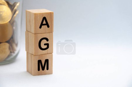Foto de AGM texto sobre bloques de madera con fondo de cubierta blanca. Concepto de junta general anual. - Imagen libre de derechos