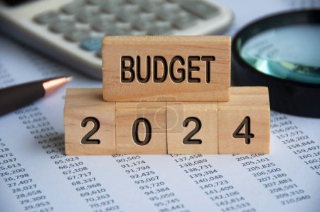Haushaltsplan 2024 Text auf Holzklötzen mit Datenanalyse und Bürokonzept Hintergrund. Haushaltskonzept.