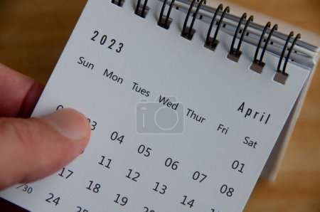 Photo for Top view of hand flipping April 2023 calendar. Calendar concept. - Royalty Free Image