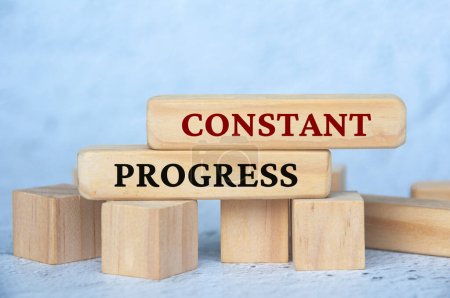 Constant progress text on wooden blocks with blur cover background. Business culture and Operational excellence concept.