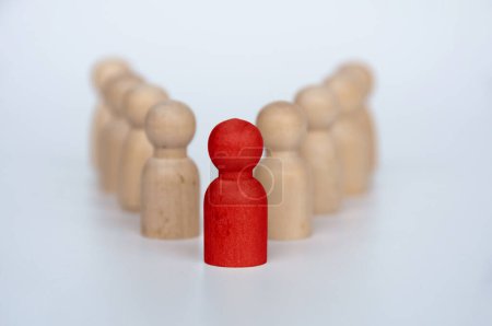 Foto de Figura de madera roja que representa a un líder que lidera otra figura. Concepto de liderazgo. - Imagen libre de derechos