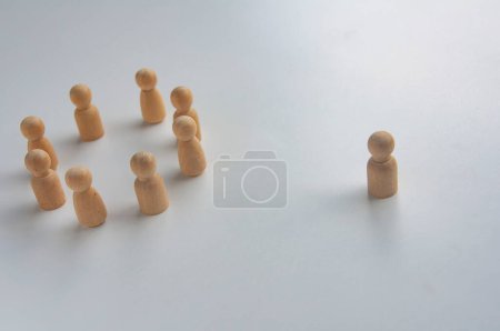 Photo for A wooden figure isolated from the rest of the wooden figures. - Royalty Free Image