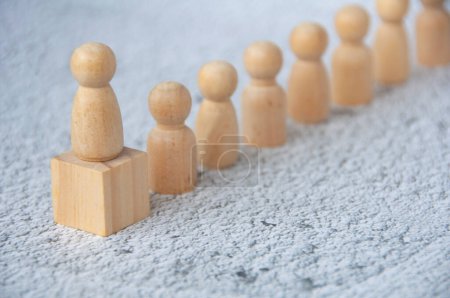 Photo for A wooden figure on top of wooden block representing a leader leading other figure. Leadership concept - Royalty Free Image