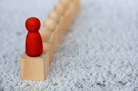Foto de Figura de madera roja en la parte superior del bloque de madera que representa a un líder que lidera otra figura. Concepto de liderazgo. - Imagen libre de derechos