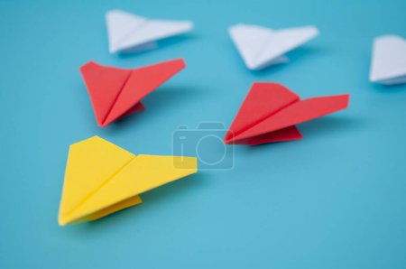 Téléchargez les photos : Vue latérale de l'origami avion en papier jaune menant avions en papier rouge et blanc. - en image libre de droit