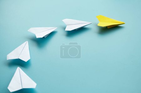 Téléchargez les photos : Vue du dessus de l'origami d'avion en papier jaune menant d'autres avions en papier blanc avec un espace personnalisable pour le texte. - en image libre de droit
