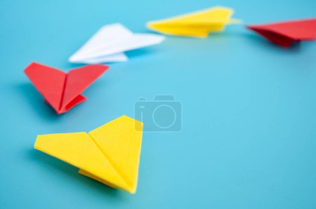 Téléchargez les photos : Origami avion en papier jaune menant d'autres avions en papier sur fond bleu. Concept de leadership. - en image libre de droit