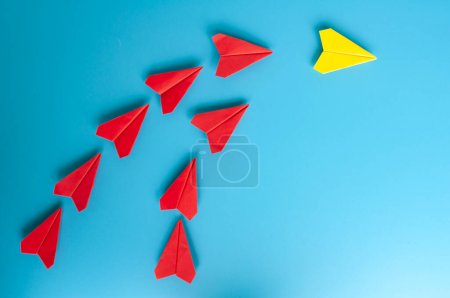 Téléchargez les photos : Vue du dessus de l'origami de l'avion en papier jaune menant avions en papier rouge. Avec espace de copie pour le texte. - en image libre de droit