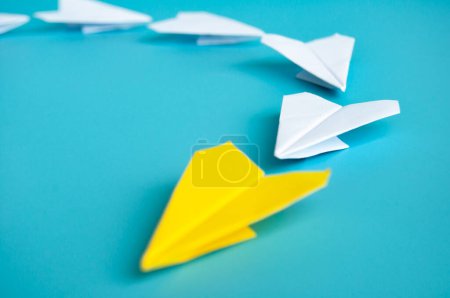 Téléchargez les photos : Vue basse de l'origami avion en papier jaune menant avions en papier blanc. Avec espace de copie pour le texte - en image libre de droit