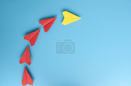 Téléchargez les photos : Vue du dessus des avions en papier jaune origami menant avions en papier rouge. Avec espace de copie pour le texte - en image libre de droit