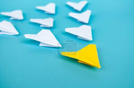 Téléchargez les photos : Vue du dessus de l'origami d'avion en papier jaune menant d'autres avions en papier blanc. - en image libre de droit
