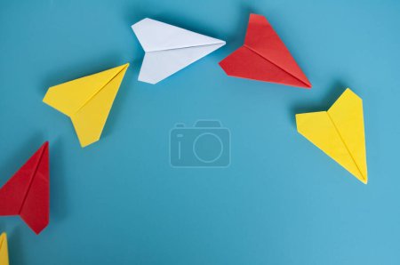 Téléchargez les photos : Vue du dessus de l'origami d'avion en papier jaune menant d'autres avions en papier. Avec espace de copie pour le texte - en image libre de droit