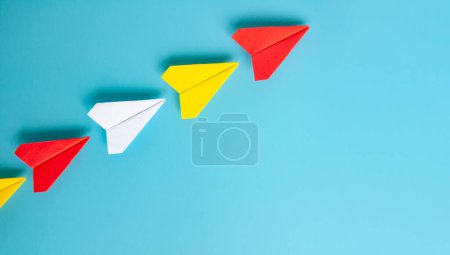 Téléchargez les photos : Vue du dessus de l'origami de l'avion en papier rouge menant d'autres avions en papier. Avec espace de copie pour le texte. - en image libre de droit