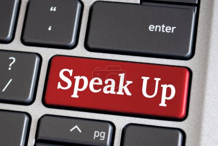 Speak up text on red color laptop keyboard. Courage to speak up concept.