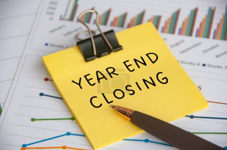 Photo for Year End Closing text on sticky note with statistic and graph background. - Royalty Free Image