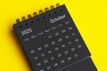 Oktober 2025 schwarz-weißer Tischkalender auf gelbem Hintergrund. Kalenderkonzept.
