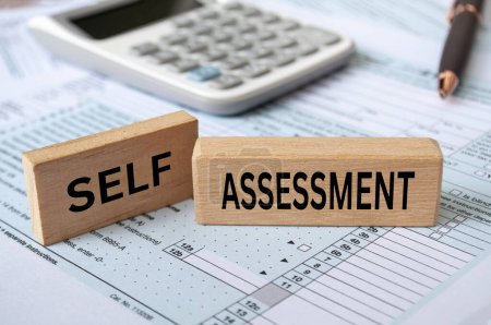 Photo for Self assessment text on wooden blocks with tax form and calculator background. Taxation concept. - Royalty Free Image