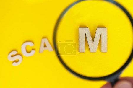 Photo for Top view of magnifying glass focusing on the work SCAM. Cyber crime concept. - Royalty Free Image